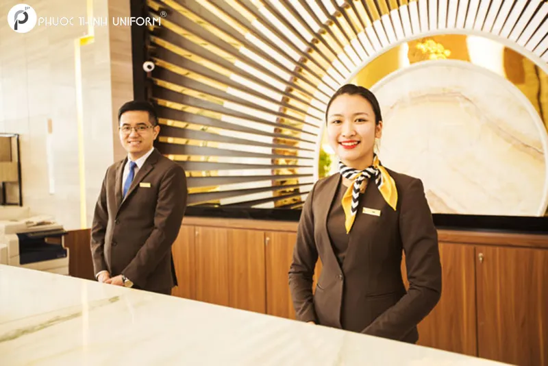Mẫu đồng phục lễ tân sang trọng kết hợp giữa sơ mi và vest, điểm nhấn là khăn thắt ở cổ